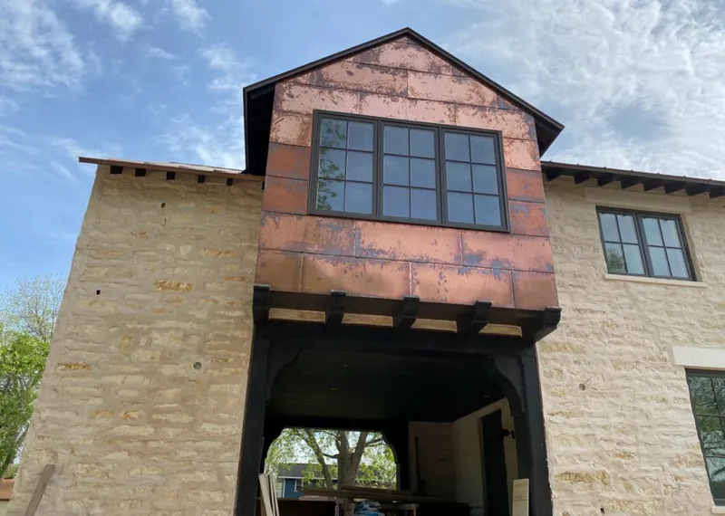 Copper metal panel facade on a stone building for Roof Repair in Hillsdale
